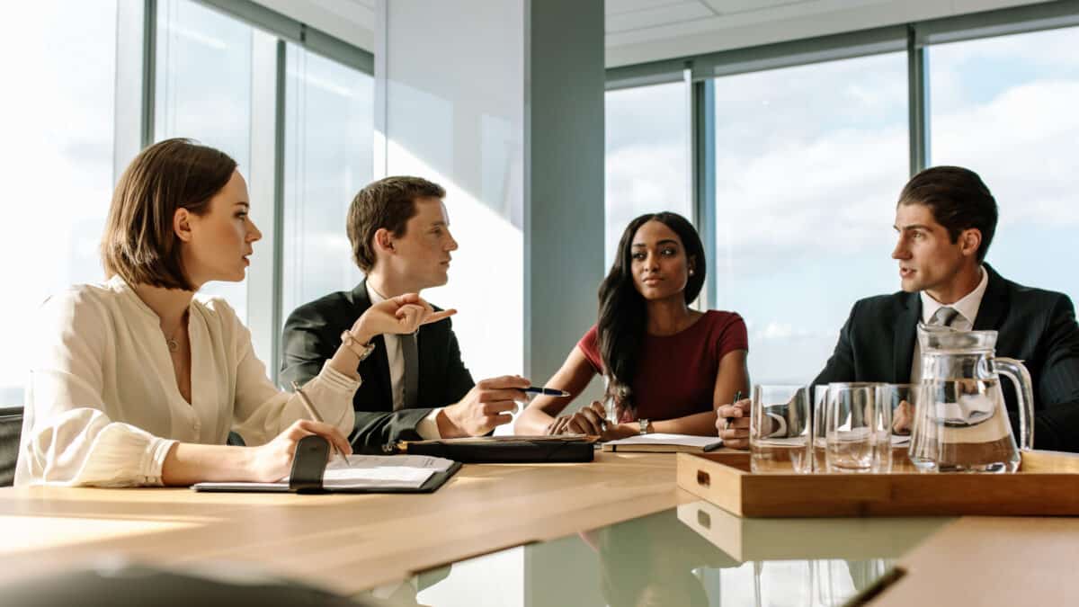 Four attorneys discussing transcription services in conference room