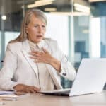 Concerned businesswoman reacting to a data breach on her laptop in a modern office setting.