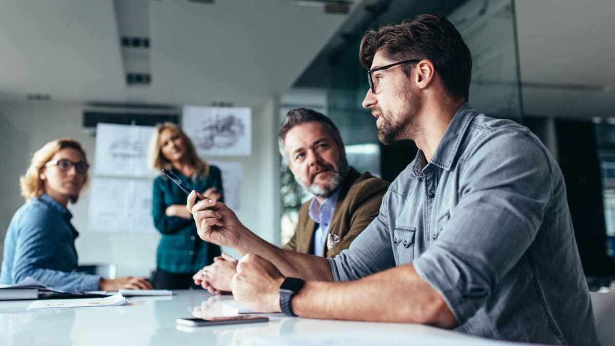 Business professionals discussing cybersecurity planning in a modern office setting.