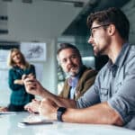 Business professionals discussing cybersecurity planning in a modern office setting.