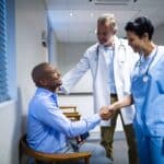 Physician and nurse greeting a patient, highlighting AxiScribe AI's real-time transcription benefits