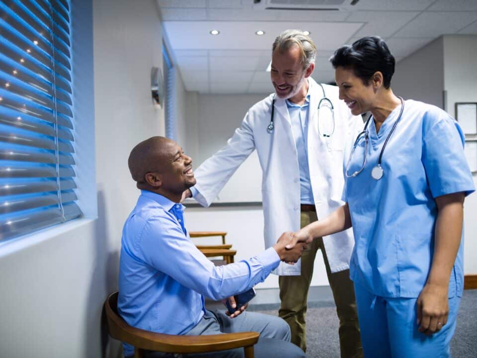 Physician and nurse greeting a patient, highlighting AxiScribe AI's real-time transcription benefits