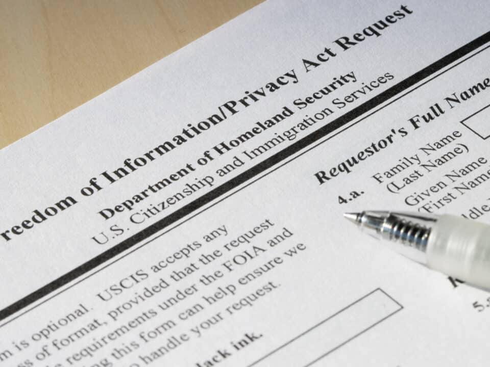 FOIA request form close-up with pen, highlighting the role of transcription in government transparency.